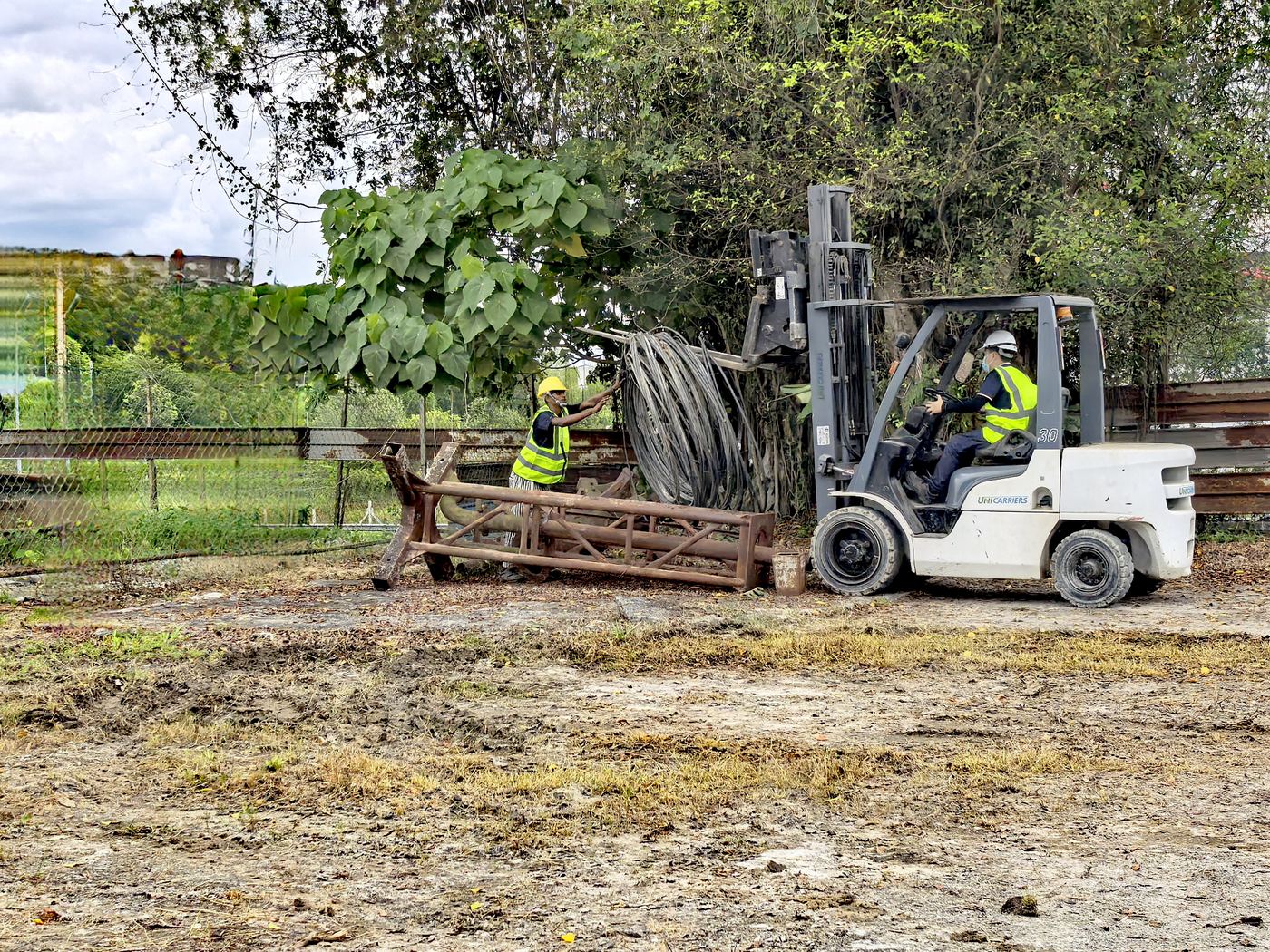 XXL Space Share forklift lifting a steel truss while a worker guides it