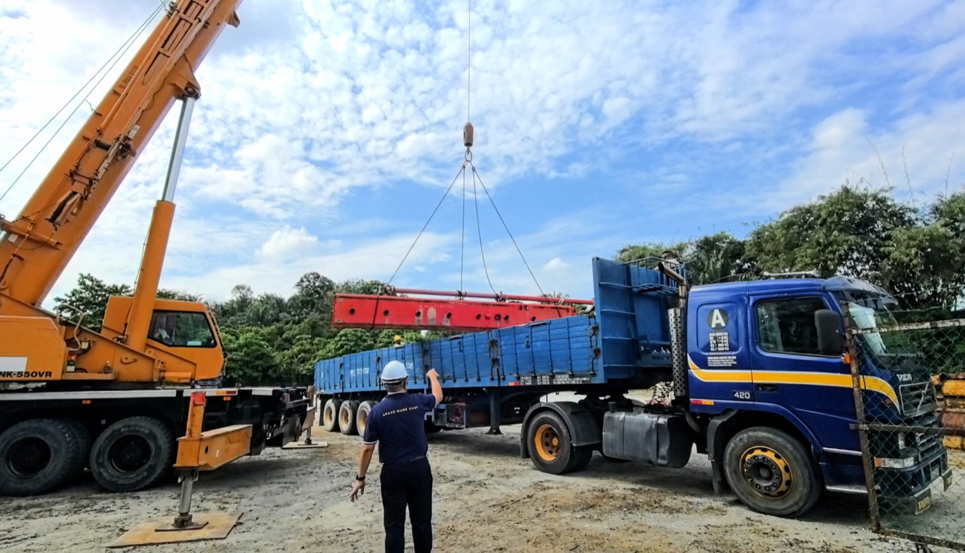 XXL Space Share crew craning a steel beam onto a lorry for delivery to a job site